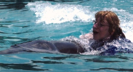 Chelsie riding a dolphin at Discovery Cove, Orlando, FL
